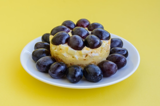 A lendária salada Tiffany em camadas com uvas, frango e queijo no fundo amarelo. O nome vem do apelido da senhora que postou a receita da salada no portal de culinária.