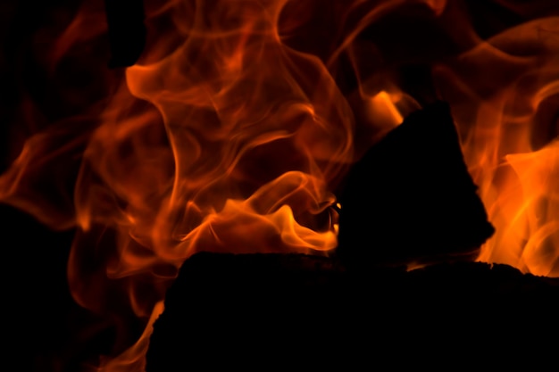 A lenha está queimando com um fogo laranja na lareira Aquecimento da casa sem eletricidade