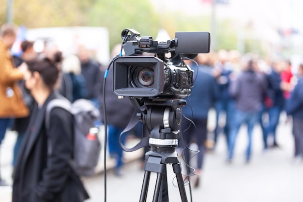 A lente da câmera da TV no foco desfocou as pessoas no fundo