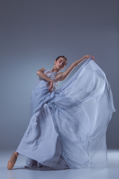 A linda bailarina dançando em um vestido longo azul