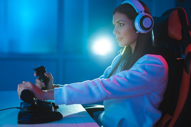 Foto a linda garota gamer jogando videogame na sala escura