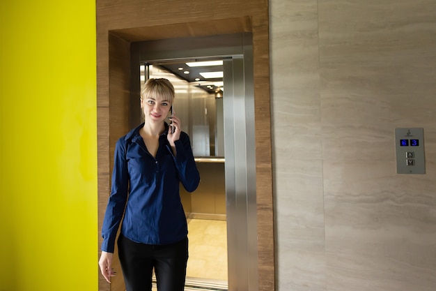 Foto a loira de negócios no escritório no trabalho, com o telefone