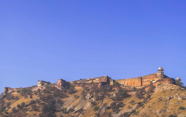 A longa muralha na montanha do forte amber em jaipur, índia