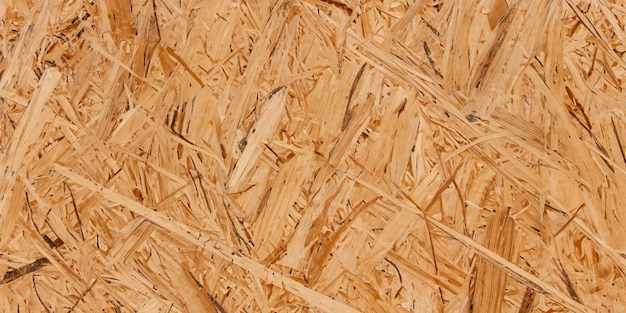 A madeira prensada OSB apresenta uma superfície texturizada com um padrão de lascas de madeira prensada