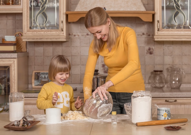 A mãe e o filho pequeno estão cozinhando na cozinha.