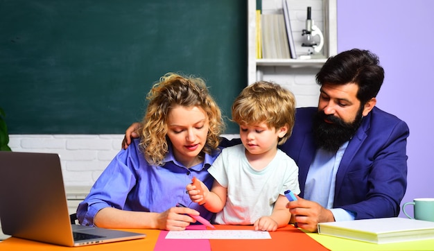 A mãe e o pai da família feliz ajudam a criança na primeira vez na escola, na escola da família feliz, na matemática