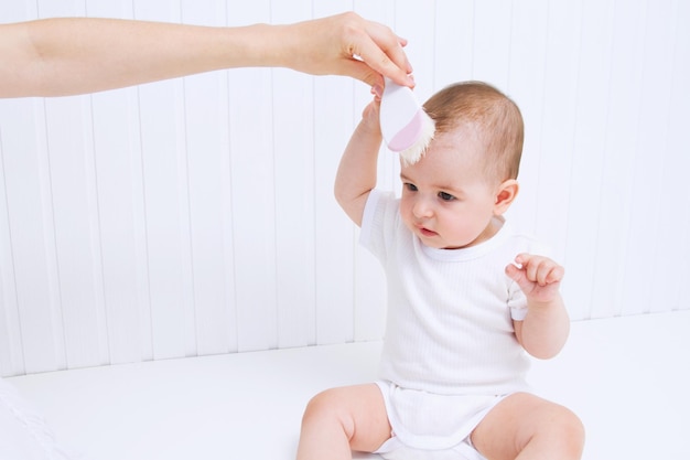 A mãe está penteando o cabelo bonito do bebê