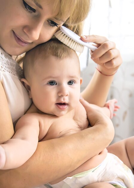 A mãe está penteando o cabelo do bebezinho