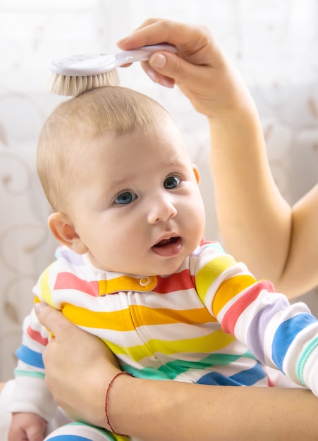 A mãe está penteando o cabelo do bebezinho