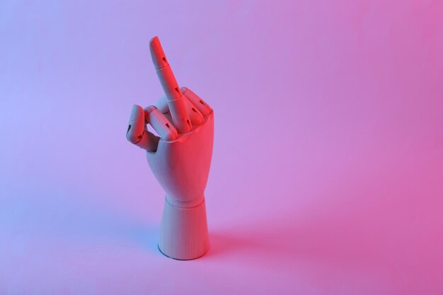 A mão de madeira mostra um gesto indecente do dedo médio em luz de néon de gradiente azul rosa