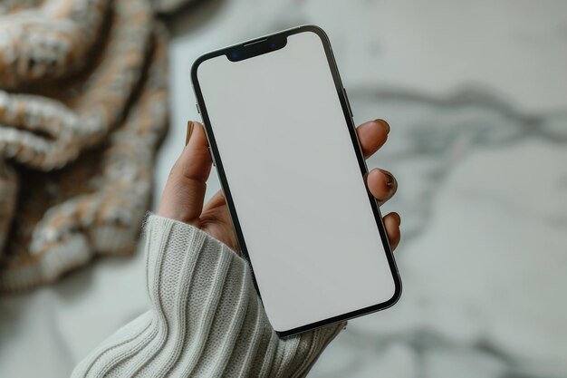 A mão de um homem está segurando um celular com uma tela branca e um fundo branco