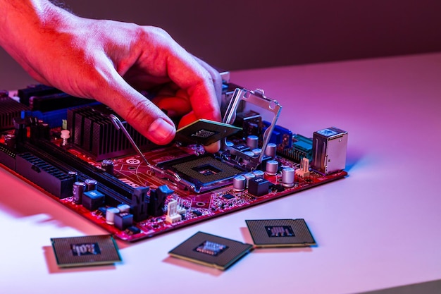 A mão de um homem insere um processador no chipset da placa-mãe