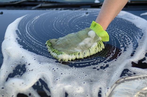 Foto a mão de um homem lava o carro