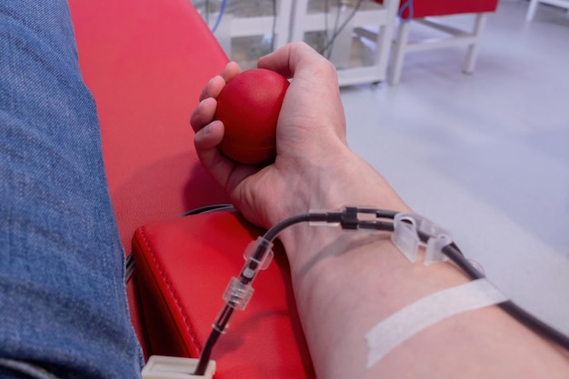 A mão de um homem segurando uma bola de borracha para bombear sangue durante a doação Sangue Médico Equipamento Dia Conexão Estilos de vida Injeção Preparação Tecnologia Paciente Adulto Hospital Man Care