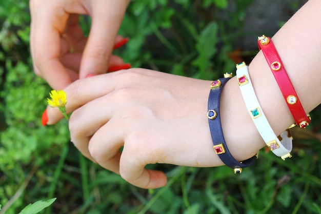 Foto a mão de uma criança está usando uma pulseira com uma flor amarela.