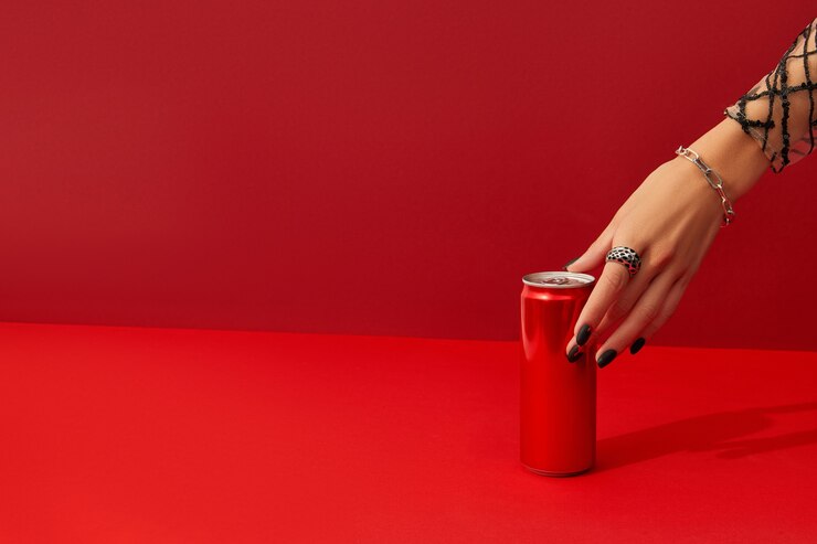 A mão de uma mulher com um design de unhas assustador mostra um fundo vermelho sob a luz do sol