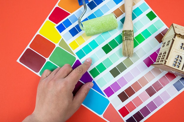 A mão de uma mulher escolhe uma cor em uma paleta de cores o conceito de reparar um apartamento ou casa escolha de cor para pintura de parede