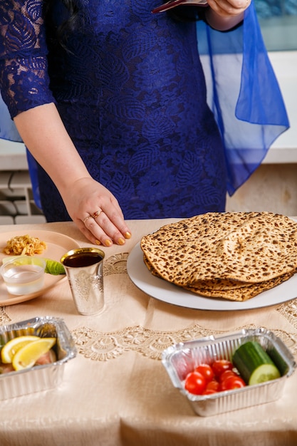 Foto a mão de uma mulher na mesa do seder da páscoa está comendo um choroset