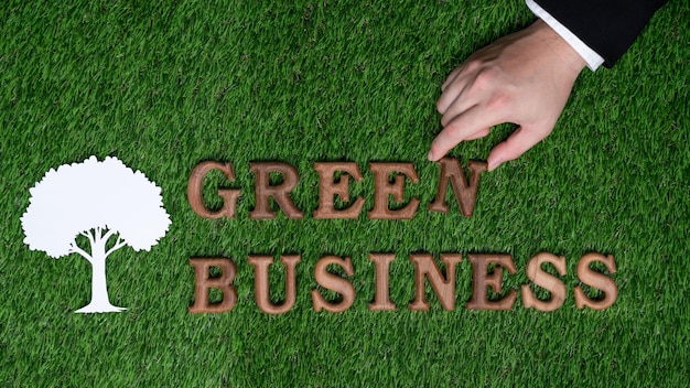 A mão do empresário organiza a mensagem no Green Business como conceito de esforço corporativo para o compromisso com a RSE ou conceito de responsabilidade social corporativa para Gyre ambientalmente sustentável