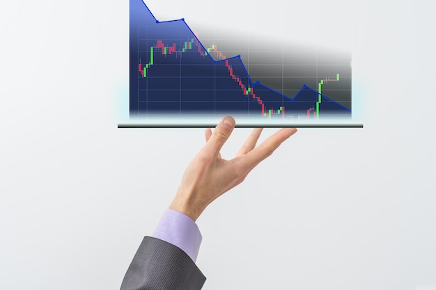 A mão do empresário segura uma exibição de gráfico de ações em uma tela visual. Ele mostra sinais de estoques em queda em 2021 com um indicador de gráfico. Conceitos de taxas de juros financeiras e taxas de hipoteca.