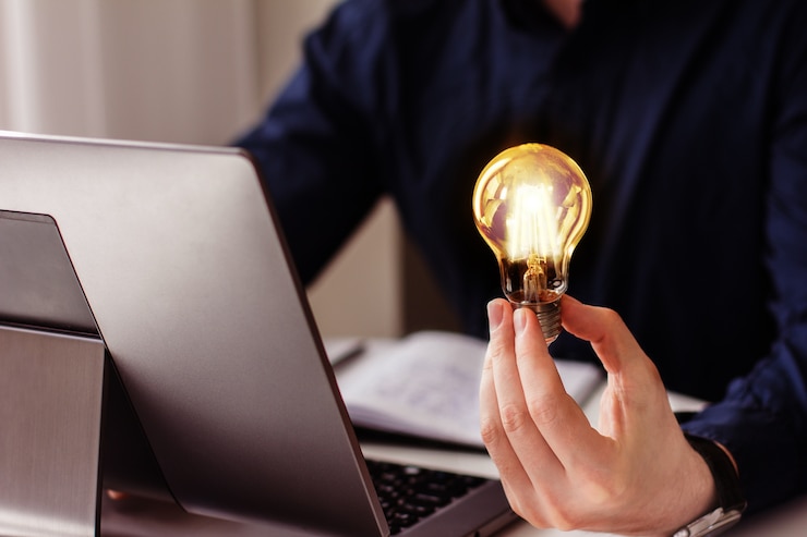 A mão do empresário segura uma lâmpada acesa, ideia, inovação e inspiração de conceito