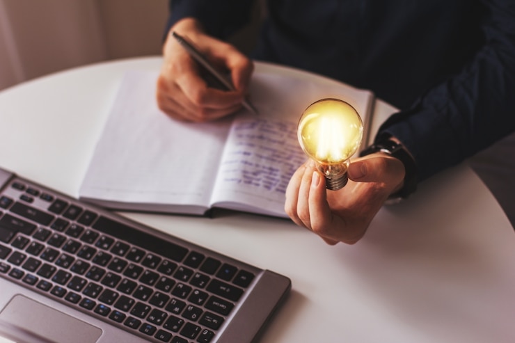 A mão do empresário segura uma lâmpada acesa, ideia, inovação e inspiração de conceito