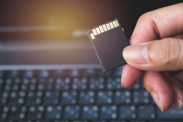 A mão do fotógrafo que guarda o cartão de memória para preparar o encaixe ao computador.