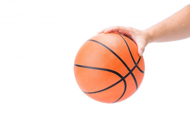 A mão do homem asiático está segurando ou apalpando uma bola de basquete laranja na mão isolado