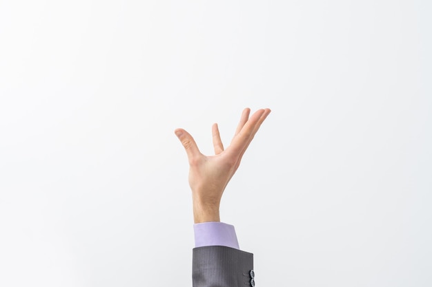 A mão do homem de terno implora por algo isolado no fundo branco. Palma para cima, close-up. Produto de alta resolução.