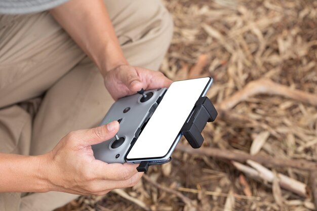 A mão do homem está controlando um drone com controle remoto