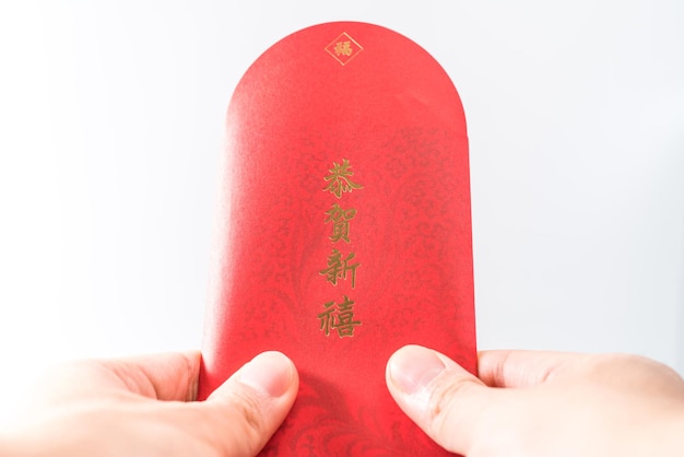 A mão do homem segurando com envelope vermelho chinês (pacote vermelho). Conceito de ano novo chinês. ("GÅ nghÃ¨ xÄ« nxÇ "em chinês significa" Desejo-lhe prosperidade ")