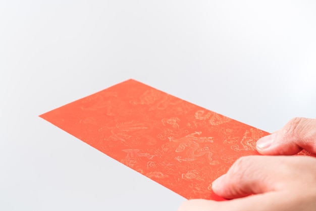 A mão do homem segurando com envelope vermelho chinês (pacote vermelho). Conceito de ano novo chinês.