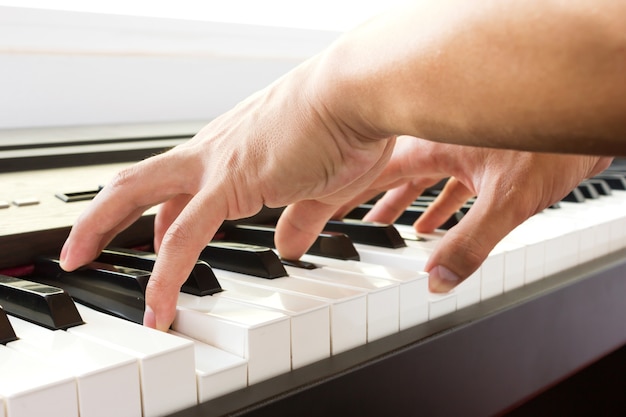 A mão do homem tocando piano.