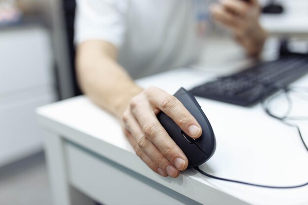 a mão do homem usa um mousejoystick de computador ergonômico vertical