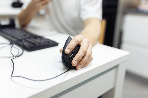 a mão do homem usa um mousejoystick de computador ergonômico vertical