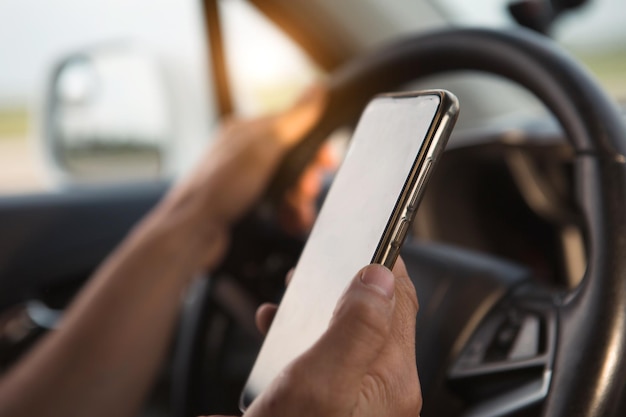 A mão do motorista ao volante segura um smartphone Navigator comunicação de navegação por satélite no viva-voz de segurança rodoviária do carro