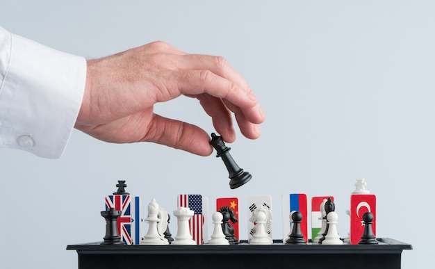 A mão do político move uma peça de xadrez. Foto conceitual de um jogo político e estratégia.