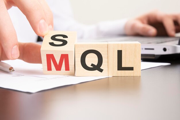 A mão do símbolo SQL ou MQL gira os cubos e altera as palavras 'lead qualificado de vendas SQL' para 'lead qualificado de marketing MQL'