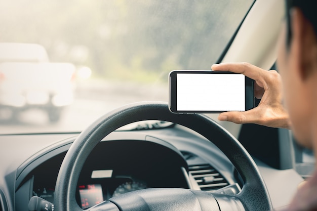 A mão dos homens está usando smartphones nos carros.