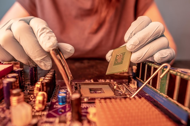 A mão enluvada do engenheiro está segurando o chip da CPU no fundo da microeletrônica de hardware de alta tecnologia da placa-mãe
