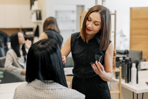 A maquiadora trabalha em seu salão aplica maquiagem profissional na indústria de beleza, transformação de maquiagem.