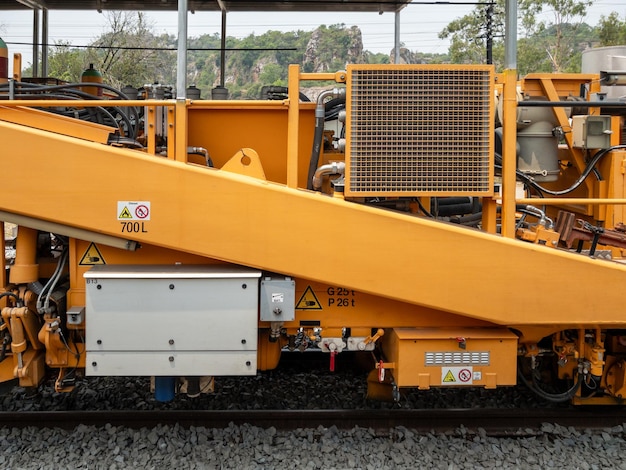 Foto a máquina de tampagem de lastro para trabalhar para manter o travesseiro e a pedra de lastro na nova linha ferroviária do projeto de via dupla vista frontal com o espaço de cópia