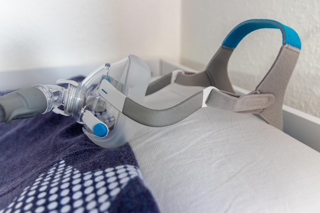 A máscara de CPAP contra a apneia obstrutiva do sono no travesseiro ajuda os pacientes como máscara respiratória e capacete