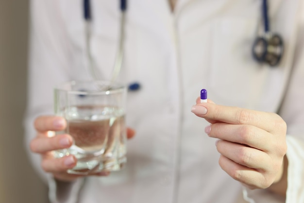 A médica mostra uma pílula em seu remédio de mão para vitaminas de tratamento para saúde