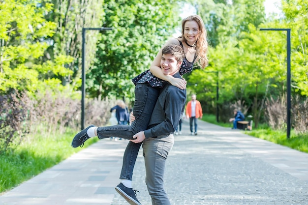 A menina abraça o cara por trás Casal feliz passeando A menina agradece o presente