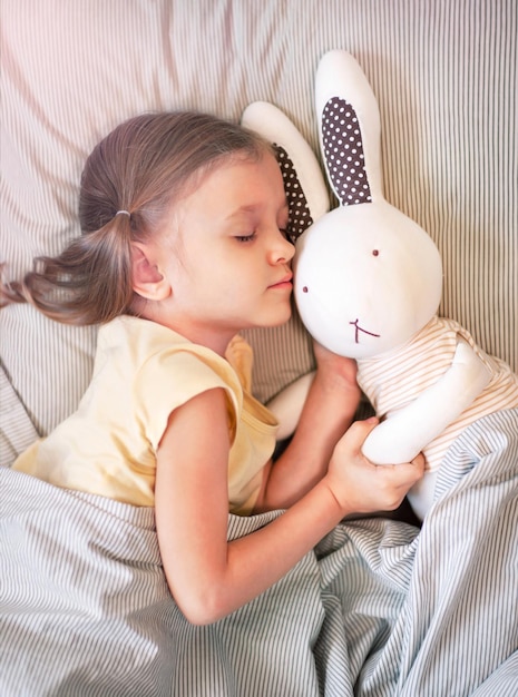 A menina adormeceu com um coelho de pano