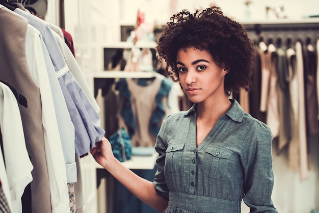 Foto a menina afro-americana bonita está olhando a câmera.