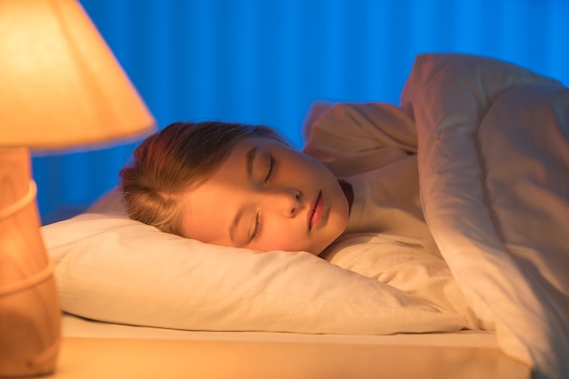 A menina bonita dormindo na cama. Noite noite