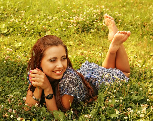 A menina bonita nova coloca em uma grama