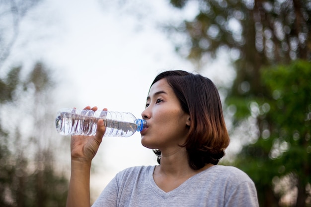 A menina bonito esporte beber água depois de seu exercício